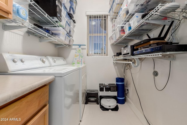 clothes washing area with cabinets and independent washer and dryer