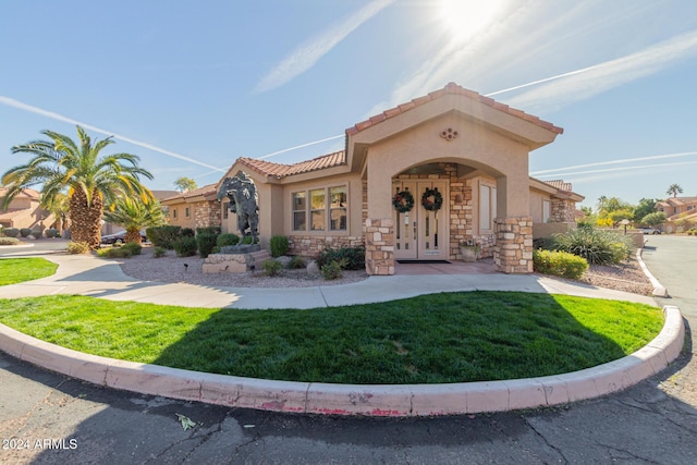 mediterranean / spanish house featuring a front lawn