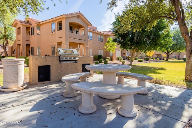 view of property's community with a lawn and exterior kitchen