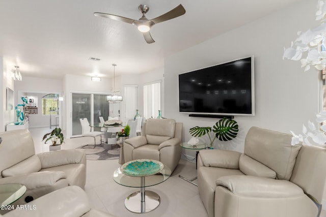 living room with ceiling fan with notable chandelier