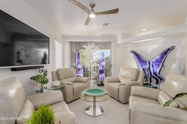 living room featuring ceiling fan with notable chandelier