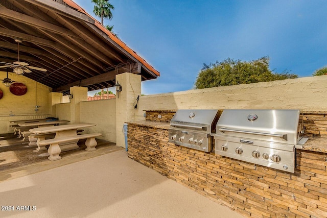 view of patio / terrace with an outdoor kitchen, ceiling fan, and grilling area