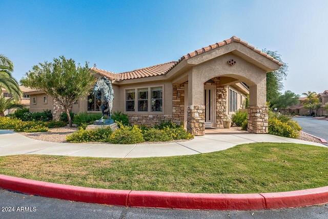 mediterranean / spanish house with a front yard