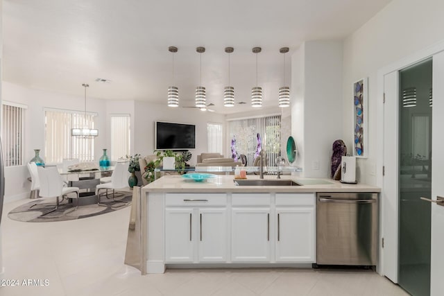 kitchen featuring dishwasher, sink, an inviting chandelier, pendant lighting, and white cabinets