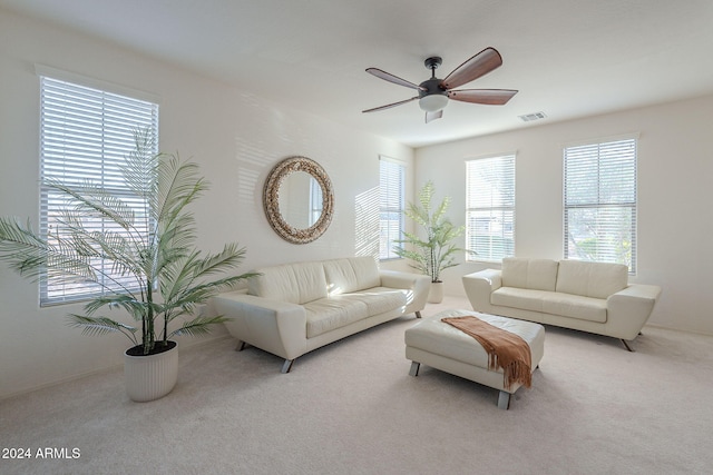 carpeted living room with ceiling fan