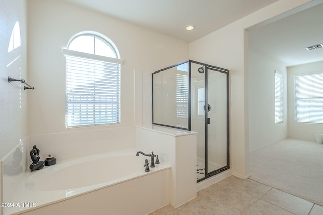 bathroom featuring tile patterned flooring, independent shower and bath, and a healthy amount of sunlight