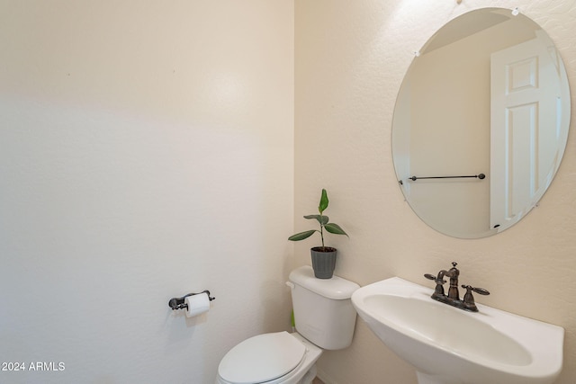 half bathroom featuring toilet and a sink