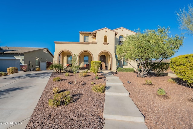 mediterranean / spanish-style house featuring a porch, concrete driveway, and stucco siding