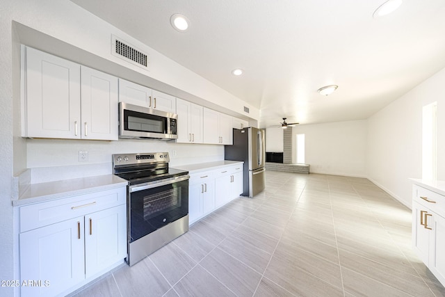 4528 W Butler Dr, Glendale, AZ 85302 - kitchen with stainless steel appliances, light countertops, a ceiling fan, white cabinets, and light tile patterned flooring