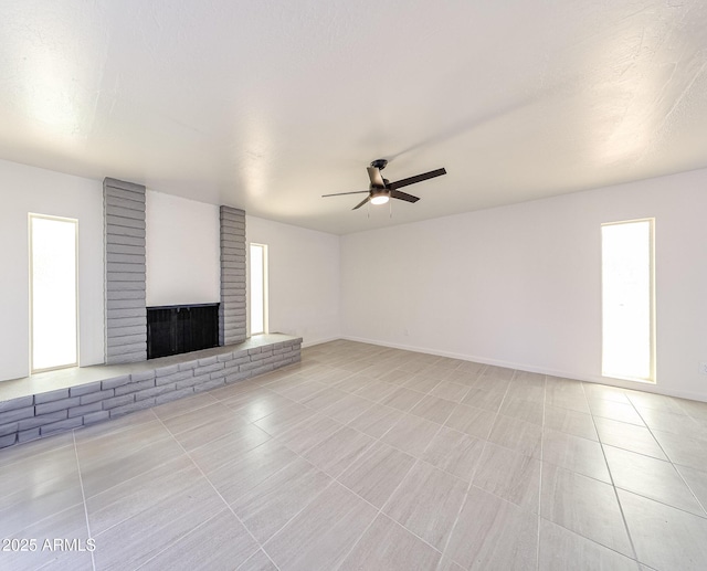 4528 W Butler Dr, Glendale, AZ 85302 - unfurnished living room with a ceiling fan, a fireplace, light tile patterned flooring, and baseboards