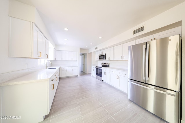 4528 W Butler Dr, Glendale, AZ 85302 - kitchen featuring appliances with stainless steel finishes, a sink, light countertops, white cabinets, and recessed lighting