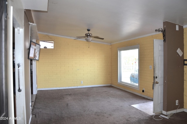 carpeted spare room with ceiling fan, brick wall, and ornamental molding