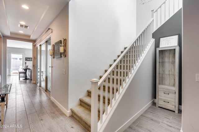 staircase with hardwood / wood-style floors