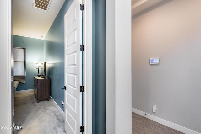 corridor with lofted ceiling and light hardwood / wood-style flooring