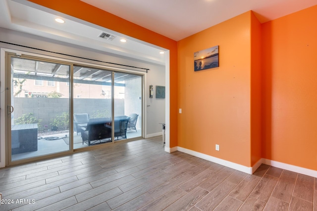 empty room with light hardwood / wood-style flooring and plenty of natural light