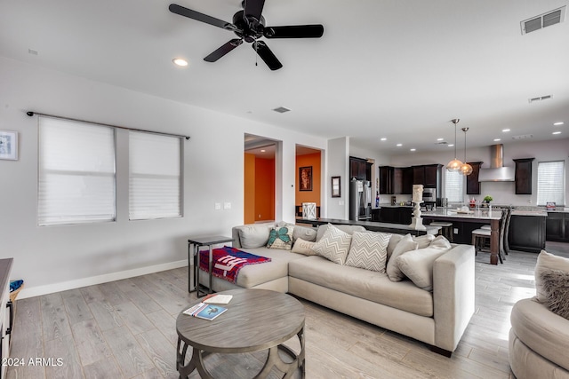 living room with light wood-type flooring and ceiling fan