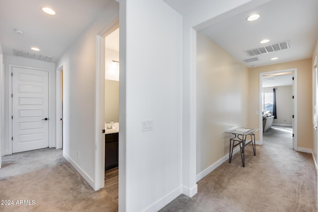 hall with light colored carpet