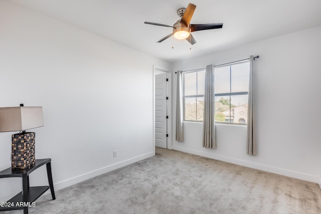 carpeted spare room featuring ceiling fan