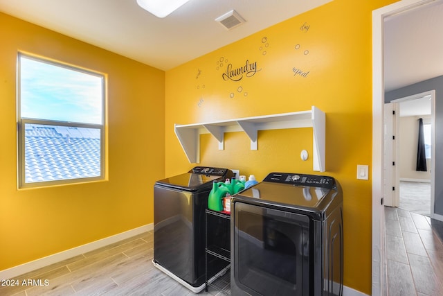 laundry area featuring wood-type flooring and washing machine and dryer