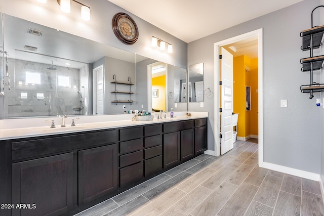 bathroom with a tile shower and vanity