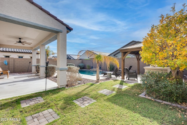 view of yard with a fenced in pool, a patio area, ceiling fan, and a gazebo