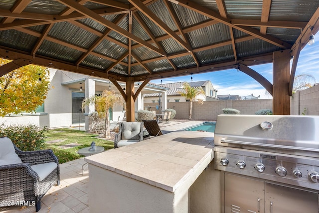 view of patio / terrace featuring a gazebo, area for grilling, and a fenced in pool