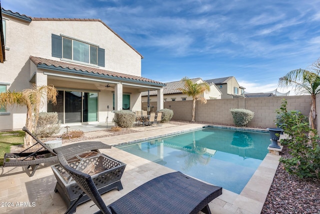 view of swimming pool featuring a patio and a fire pit