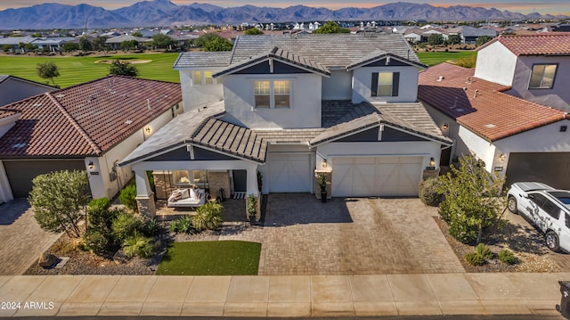 view of front of property with a garage, covered porch, and a mountain view