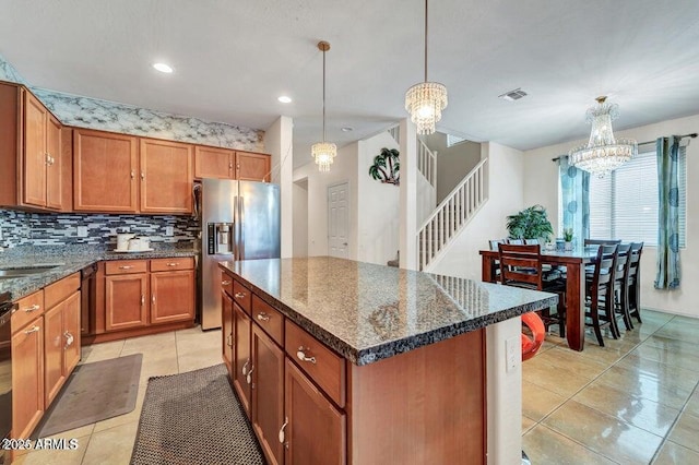 kitchen featuring a kitchen island, pendant lighting, a chandelier, light tile patterned floors, and stainless steel refrigerator with ice dispenser