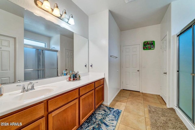 bathroom featuring tile patterned floors, a shower with shower door, and vanity