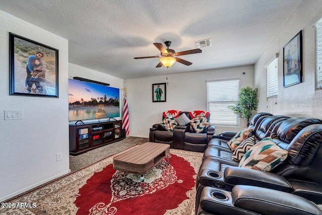 living room featuring ceiling fan and a textured ceiling