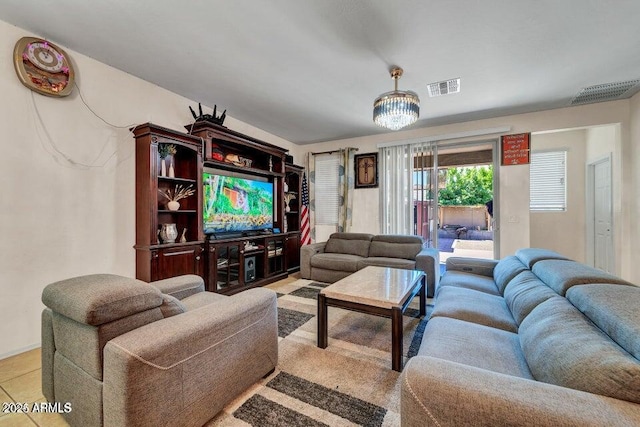 tiled living room with a notable chandelier