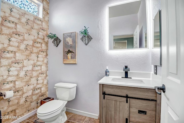 full bathroom with baseboards, a textured wall, toilet, tile patterned flooring, and vanity