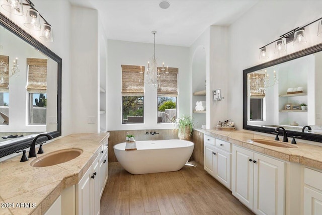 bathroom with vanity, a bathtub, an inviting chandelier, and wood-type flooring