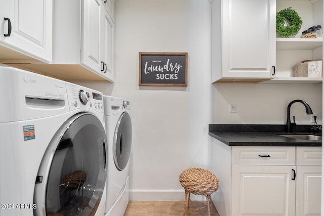 washroom featuring cabinets, washer and dryer, light hardwood / wood-style floors, and sink