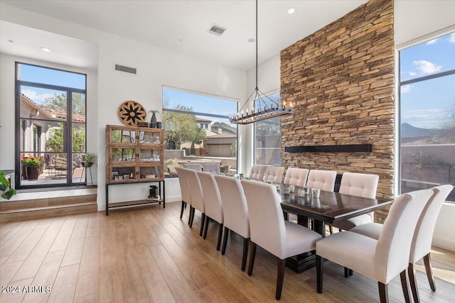 dining area with a mountain view, a chandelier, and light hardwood / wood-style flooring