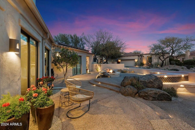 pool at dusk featuring a patio area