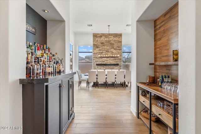 bar with pendant lighting and light wood-type flooring