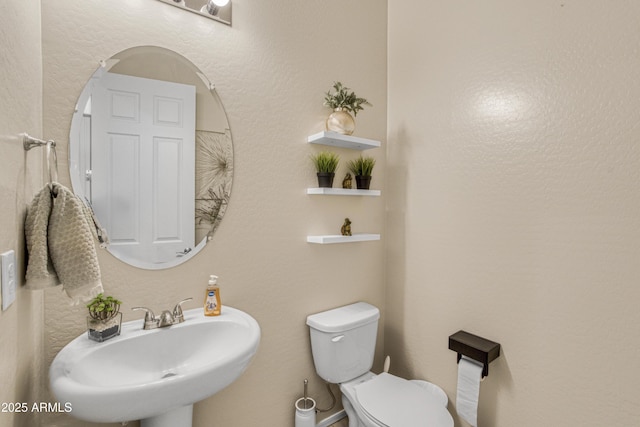half bathroom with toilet and a sink