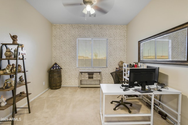 office area with brick wall, ceiling fan, visible vents, baseboards, and light colored carpet