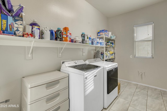 washroom with light tile patterned floors, washing machine and dryer, laundry area, and baseboards