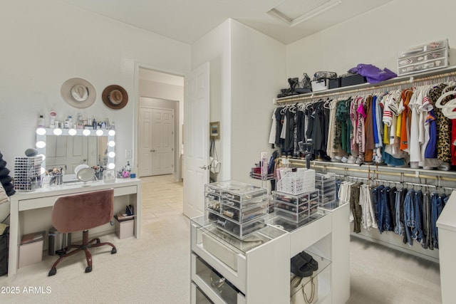 walk in closet with attic access and carpet flooring