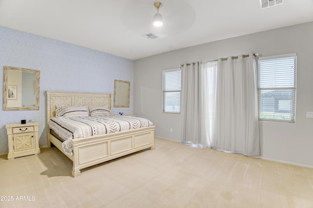 bedroom with visible vents, ceiling fan, light colored carpet, and baseboards