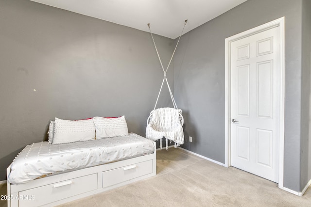 sitting room with baseboards and light colored carpet