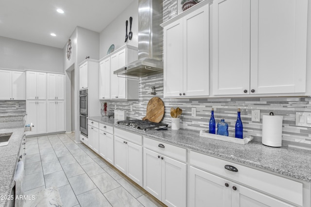 kitchen with white cabinetry, tasteful backsplash, stainless steel appliances, and wall chimney exhaust hood