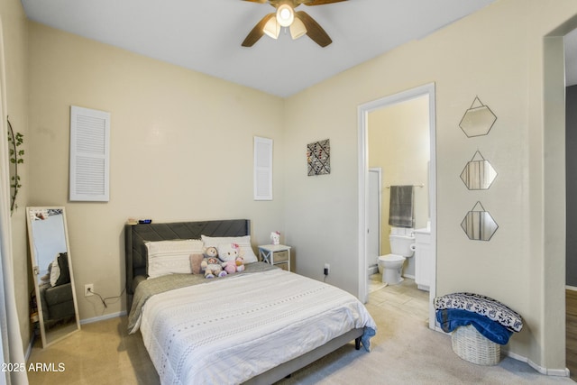 bedroom with connected bathroom, a ceiling fan, light carpet, and baseboards