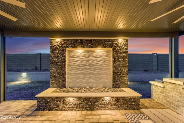 patio terrace at dusk featuring fence