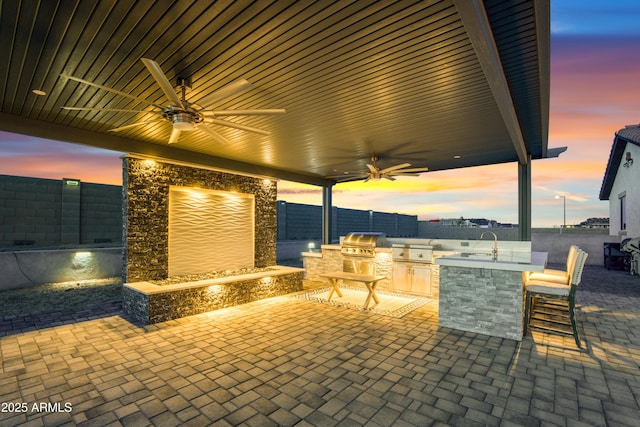 view of patio / terrace with a grill, area for grilling, ceiling fan, an outdoor bar, and a fenced backyard