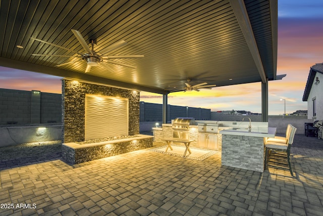 view of patio / terrace featuring area for grilling, grilling area, ceiling fan, a sink, and a fenced backyard