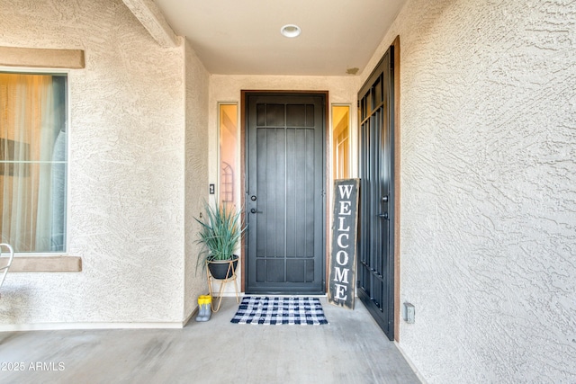 doorway to property featuring stucco siding